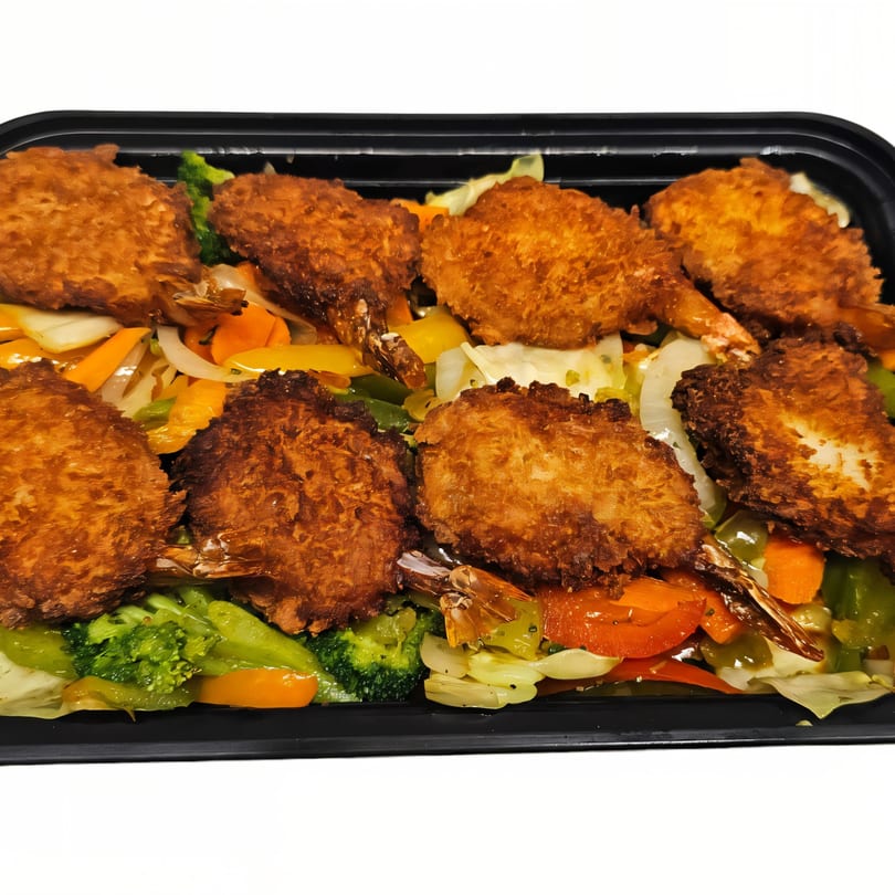 Crispy fried shrimp with tails on, served over a bed of colorful stir-fried vegetables in a black container.